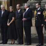
              Britain's Prince Andrew, left, Sophie, Countess of Wessex, and Prince Edward, third left, await the arrival of the hearse carrying the coffin of Queen Elizabeth II, draped with the Royal Standard of Scotland, as it completes its journey from Balmoral to the Palace of Holyroodhouse in Edinburgh, Scotland, Sunday Sept. 11, 2022. (Aaron Chown/Pool via AP)
            