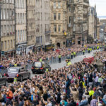 
              The hearse carrying the coffin of Queen Elizabeth II, draped with the Royal Standard of Scotland, passes on the Royal Mile, Edinburgh, Sunday, Sept. 11, 2022 on the journey from Balmoral to the Palace of Holyroodhouse in Edinburgh, where it will lie in rest for a day. (Jane Barlow/Pool Photo via AP)
            
