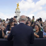 
              FILE - Britain's King Charles III, back to camera, greets well-wishers as he walks by the gates of Buckingham Palace following Thursday's death of Queen Elizabeth II, in London, Friday, Sept. 9, 2022.  King Charles III faces the task of preserving a 1,000-year-old monarchy that his mother nurtured for seven decades but that faces an uncertain future. The challenge is immense. (Yui Mok/Pool Photo via AP, File)
            
