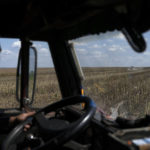 
              A worker drives his truck past a tractor harvesting sunflowers on a field in Donetsk region, eastern Ukraine, Friday, Sept. 9, 2022. Agriculture is a critical part of Ukraine's economy, accounting for about 20% of its gross national product and 40% of its export revenues before the war, according to the United Nations' Food and Agriculture Organization. The country is a key agricultural exporter and is often described as the breadbasket of Europe. (AP Photo/Leo Correa)
            