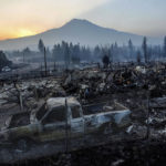 
              The sun rises over Mt. Shasta and homes destroyed by the Mill Fire on Saturday, Sept. 3, 2022, in Weed, Calif. (AP Photo/Noah Berger)
            