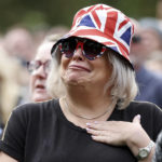 
              A woman reacts as she watches the Queen Elizabeth II funeral on a giant screen set near Windsor Castle, in Windsor, England, Monday, Sept. 19, 2022, before the committal service at St George's Chapel of Queen Elizabeth II. (Alex Pantling/Pool photo via AP)
            