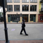 
              FILE - A police officer walks down a nearly deserted Bourbon Street during Mardi Gras in the French Quarter of New Orleans, Tuesday, Feb. 16, 2021. Hoping to beef up a dwindling police force amid a rise in violent crime, New Orleans officials announced a three-year $80 million plan Thursday, Sept. 8, 2022, offering raises for all officers, free health care and $30,000 in incentive payments for new hires. (AP Photo/Gerald Herbert, File)
            