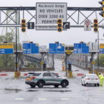
              Police block lanes of traffic as both Halifax harbor bridges were closed in Dartmouth, N.S. on Saturday, Sept. 24, 2022. Strong rains and winds lashed the Atlantic Canada region as Fiona closed in early Saturday as a big, powerful post-tropical cyclone, and Canadian forecasters warned it could be one of the most severe storms in the country's history. (Andrew Vaughan /The Canadian Press via AP)
            