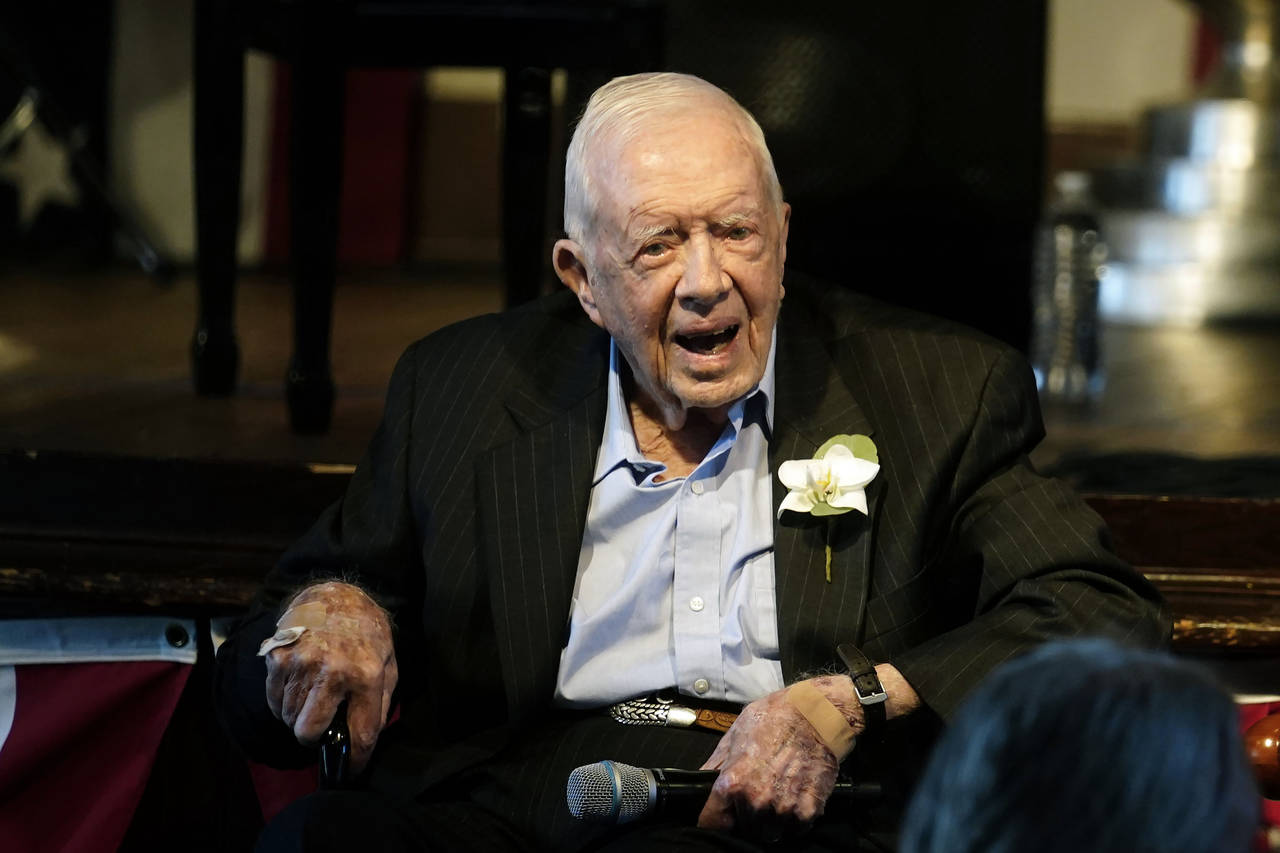 FILE - Former President Jimmy Carter reacts as his wife Rosalynn Carter speaks during a reception t...