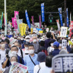 
              A street near the parliament is packed with protesters against a state funeral for Japan's former Prime Minister Shinzo Abe, in Tokyo Tuesday, Sept. 27, 2022. The rare and controversial state funeral for assassinated Abe began Tuesday in tense Japan where the event for one of the country's most divisive leaders has deeply split public opinion. (Kyodo News via AP)
            