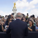 
              Britain's King Charles III, back to camera, greets well-wishers as he walks by the gates of Buckingham Palace following Thursday's death of Queen Elizabeth II, in London, Friday, Sept. 9, 2022. King Charles III, who spent much of his 73 years preparing for the role, planned to meet with the prime minister and address a nation grieving the only British monarch most of the world had known. He takes the throne in an era of uncertainty for both his country and the monarchy itself. (Yui Mok/Pool Photo via AP)
            