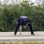 
              A Royal Canadian Mounted Police officer lays down a marker on a road outside Rosthern, Saskatchewan on Wednesday, Sept. 7, 2022. Canadian police arrested Myles Sanderson, the second suspect in the stabbing deaths of multiple people in Saskatchewan, after a three-day manhunt that also yielded the body of his brother fellow suspect, Damien Sanderson.(Heywood Yu/The Canadian Press via AP)
            