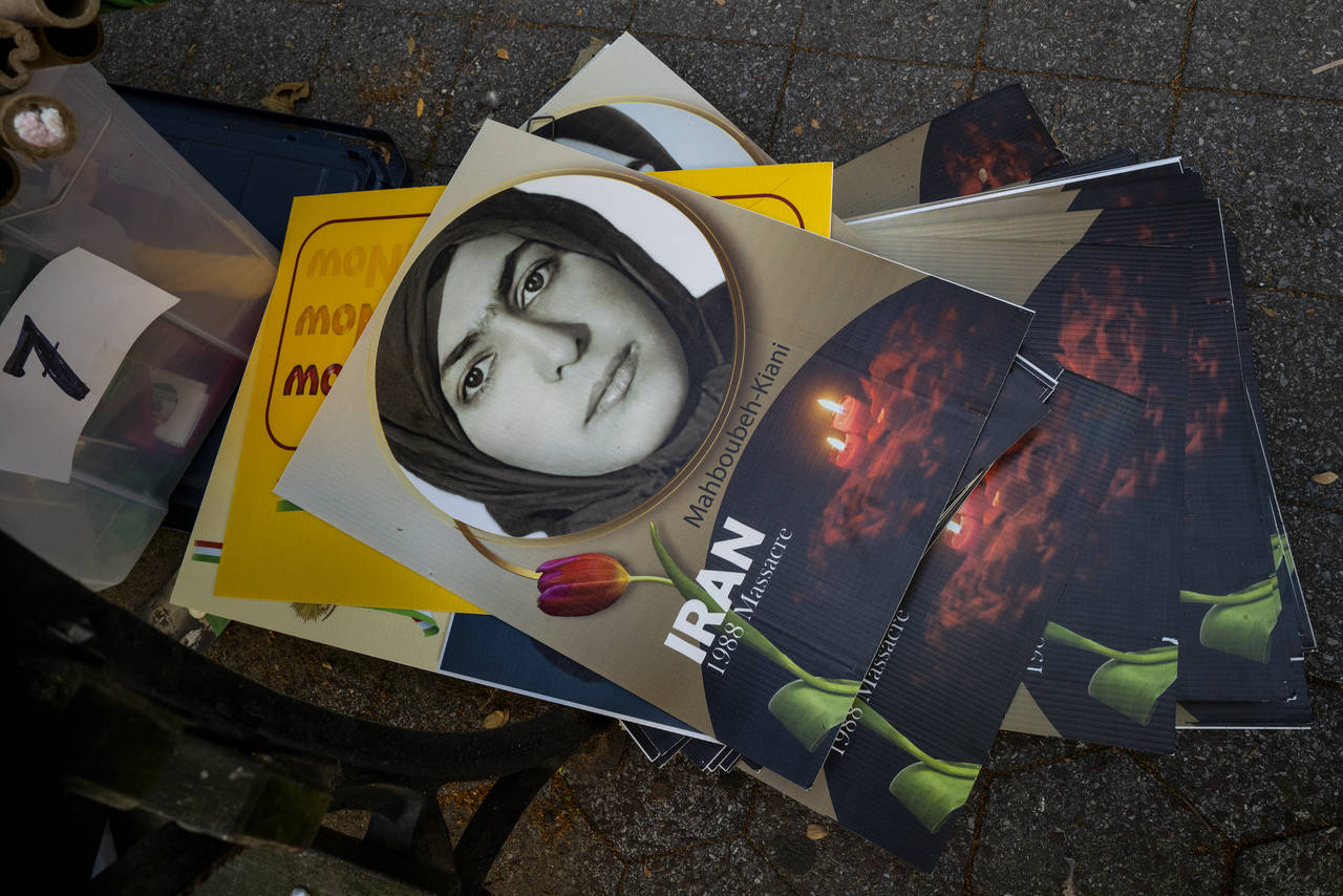 Placards used in a protest lay stacked on the ground in the midst of Iranian Americans and others d...