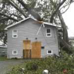 
              Fallen trees lay on a house in Glace Bay, Nova Scotia, on Sunday, Sept. 25, 2022. A day after post-tropical storm Fiona left a trail of destruction through Atlantic Canada and eastern Quebec, residents of a coastal town in western Newfoundland continued to pick through wreckage strewn across their community, easily the most damaged area in the region. (Vaughan Merchant/The Canadian Press via AP)
            
