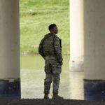
              A member of the Texas National Guard looks across the Rio Grande to Mexico from the U.S. at Eagle Pass, Texas, Friday, Aug. 26, 2022. The area has become entangled in a turf war between the Biden administration and Texas Gov. Greg Abbott over how to police the U.S. border with Mexico. (AP Photo/Eric Gay)
            