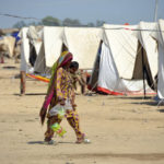 
              A woman walks at a camp as she take a refuge after leaving her flood-hit homes, in Jaffarabad, a district of Baluchistan province, Pakistan, Wednesday, Sept. 21, 2022. Devastating floods in Pakistan's worst-hit province have killed 10 more people in the past day, including four children, officials said Wednesday as the U.N. children's agency renewed its appeal for $39 million to help the most vulnerable flood victims. (AP Photo/Zahid Hussain)
            