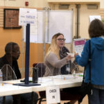 
              An election worker, center, assists voters, right, in the Massachusetts primary election at a polling place, Tuesday, Sept. 6, 2022, in Attleboro, Mass. (AP Photo/Steven Senne)
            