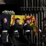 
              Pallbearers carry the coffin of Britain's Queen Elizabeth II outside St. Giles Cathedral, in Edinburgh, Scotland, Tuesday, Sept. 13, 2022. King Charles III and Camilla, the Queen Consort, flew to Belfast from Edinburgh on Tuesday, the same day the queen’s coffin will be flown to London from Scotland. (Carl Recine/Pool Photo via AP)
            