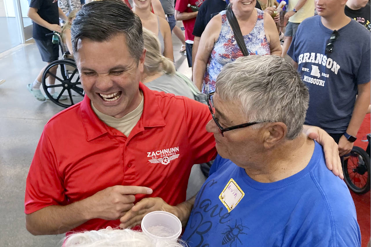 Iowa Republican candidate for Congress Zach Nunn, left, laughs while talking with Arvin Foell of Ke...