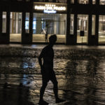 
              A man walks through a flooded street in front of a hotel powered by an oil generator during a blackout in Havana, Cuba, Wednesday, Sept. 28, 2022. Cuba remained in the dark early Wednesday after Hurricane Ian knocked out its power grid and devastated some of the country's most important tobacco farms when it hit the island's western tip as a major storm. (AP Photo/Ramon Espinosa)
            