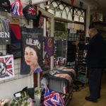 
              A man stops by a shop displaying various souvenirs of the late Queen Elizabeth II in Windsor, England, Thursday, Sept. 15, 2022. The Queen will lie in state in Westminster Hall for four full days before her funeral on Monday Sept. 19. (AP Photo/Gregorio Borgia)
            