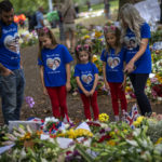 
              FILE - Jamie and Emma with their daughters, from second left, Maisie, Arabella and Elithia, stand next to flowers and messages placed for Queen Elizabeth II at Green Park memorial next to Buckingham Palace in London, Sept. 12, 2022. Because she reigned and lived for so long, Queen Elizabeth II's death was a reminder that mortality and the march of time are inexorable. (AP Photo/Emilio Morenatti, File)
            