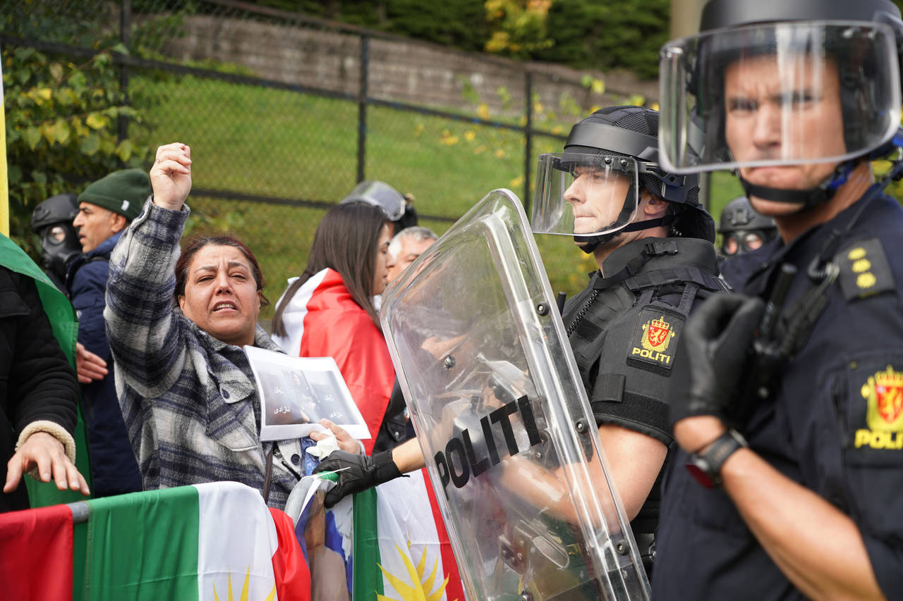 Policemen stand guard as demonstrators gather outside Iran's embassy in Oslo, Norway, Thursday, Sep...
