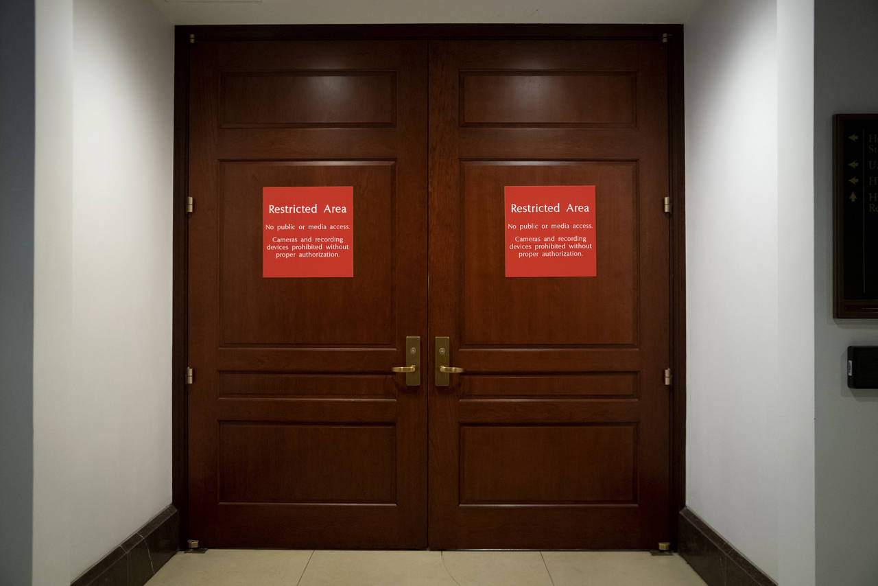 FILE - Bright red signs alert non-authorized personnel at the entrance to the House SCIF, the Sensi...