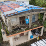 
              Jetsabel Osorio stands in her house damaged five years ago by Hurricane Maria before the arrival of Tropical Storm Fiona in Loiza, Puerto Rico, Saturday, Sept. 17, 2022. Fiona was expected to become a hurricane as it neared Puerto Rico on Saturday, threatening to dump up to 20 inches (51 centimeters) of rain as people braced for potential landslides, severe flooding and power outages. (AP Photo/Alejandro Granadillo)
            
