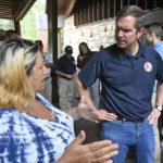 
              Kentucky Gov. Andy Beshear, right, speaks with Pansy McCoy at Jenny Wiley State Park in Prestonsburg, Ky., Tuesday, Sept. 6, 2022. Despite being a Democratic governor in a Republican dominated state, Beshear has a large amount of support from Kentucky residents. (AP Photo/Timothy D. Easley)
            