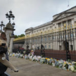 
              A dog owner pays her respect at the gates of Buckingham Palace in London, Friday, Sept. 9, 2022. Queen Elizabeth II, Britain's longest-reigning monarch and a rock of stability across much of a turbulent century, died Thursday Sept. 8, 2022, after 70 years on the throne. She was 96. (AP Photo/Kirsty Wigglesworth)
            