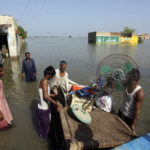 
              Victims of unprecedented flooding from monsoon rains use a cot to salvage belongings from their nearby flooded home, in Jaffarabad, Pakistan, Monday, Sept. 5, 2022. The U.N. refugee agency rushed in more desperately needed aid Monday to flood-stricken Pakistan as the nation's prime minister traveled to the south where rising waters of Lake Manchar pose a new threat. (AP Photo/Fareed Khan)
            