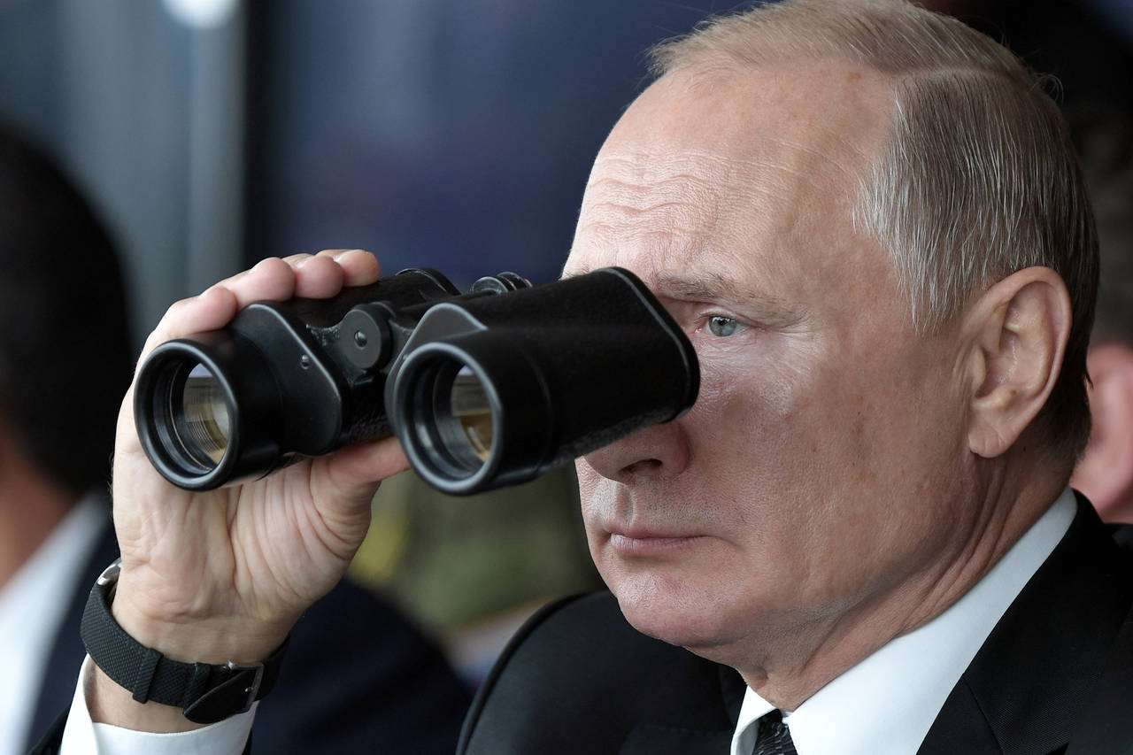 FILE - Russian President Vladimir Putin holds binoculars while watching the military exercises Cent...