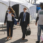 
              FILE - Jeff Page, right, also known as General Jeff, a homelessness activist and leader in the Downtown Los Angeles Skid Row Neighborhood Council, walks with U.S. District Court Judge David O. Carter, middle, and Michele Martinez, special master on the issues of homelessness, left, after a court hearing at Downtown Women's Center in Los Angeles. Los Angeles County leaders announced Monday, Sept. 12, 2022, a lawsuit settlement agreement that commits hundreds of millions of dollars to expand outreach and supportive services for homeless residents, marking the potential end of two years of litigation over the crisis of people living on the streets. (AP Photo/Damian Dovarganes, File)
            