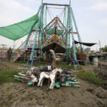 
              An amusement park worker collects a parts of a swinging horse ride after it was damaged by heavy rain, in Charsadda, Pakistan, Monday, Sept. 5, 2022. The U.N. refugee agency rushed in more desperately needed aid Monday to flood-stricken Pakistan as the nation's prime minister traveled to the south where rising waters of Lake Manchar pose a new threat. (AP Photo/Mohammad Sajjad)
            