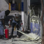 
              Security personnel extinguish a fire set by demonstrators at a gas pump during a protest against fuel price hikes and to demand that Haitian Prime Minister Ariel Henry step down, in Port-au-Prince, Haiti, Thursday, Sept. 15, 2022. (AP Photo/Odelyn Joseph)
            