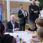 
              President Joe Biden sits and talks to children before speaking at a United Steelworkers of America Local Union 2227 event in West Mifflin, Pa., Monday, Sept. 5, 2022, to honor workers on Labor Day. (AP Photo/Susan Walsh)
            