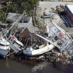
              In this aerial photo, damaged boats and debris are stacked along the shore in the aftermath of Hurricane Ian, Thursday, Sept. 29, 2022, in Fort Myers, Fla.  (AP Photo/Wilfredo Lee)
            