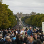 
              People stand along the Long Walk outside Windsor Castle as they wait for the coffin of Queen Elizabeth II to arrive in Windsor, England, Monday, Sept. 19, 2022. The Queen, who died aged 96 on Sept. 8, will be buried at Windsor alongside her late husband, Prince Philip, who died last year. (AP Photo/Alastair Grant, Pool)
            