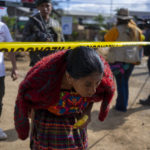 
              A relative crosses a police line after attending a meeting with a rescue worker, next to a sinkhole in Villa Nueva, Guatemala, Tuesday, Sept. 27, 2022. Search efforts were underway for a mother and daughter who disappeared when their vehicle was swallowed by a massive sinkhole. (AP Photo/Moises Castillo)
            