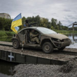 
              Ukrainian paratroopers drive on the vehicle with Ukrainian flag on the pantone bridge across Siverskiy-Donets river in the recently retaken area of Izium, Ukraine, Wednesday, Sept. 14, 2022. (AP Photo/Evgeniy Maloletka)
            