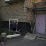 
              FILE - An elderly woman carries the frame of a damaged window at a residential area after a Russian attack in Sloviansk, eastern Ukraine, on Aug. 29, 2022. It's at night that residents of the eastern Ukrainian city of Sloviansk are most afraid, when rocket and artillery attacks happen more frequently. Shells and rockets slam into gardens and apartment buildings, sending chunks of masonry and shards of glass hurtling through the darkness. (AP Photo/Leo Correa, File)
            