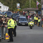 
              Members of the public line the streets in Ballater, Scotland, as the hearse carrying the coffin of Queen Elizabeth II passes through as it makes its journey to Edinburgh from Balmoral in Scotland, Sunday, Sept. 11, 2022. The Queen's coffin will be transported Sunday on a journey from Balmoral to the Palace of Holyroodhouse in Edinburgh, where it will lie at rest before being moved to London later in the week. (AP Photo/Scott Heppell)
            