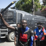 
              A man holds up a machete during a protest to demand that Haitian Prime Minister Ariel Henry step down and a call for a better quality of life, in Port-au-Prince, Haiti, Wednesday, Sept. 7, 2022. (AP Photo/Odelyn Joseph)
            