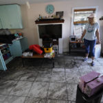 
              Cindy Bickford looks over her home damaged in Hurricane Ian, Thursday, Oct. 6, 2022, in Pine Island, Fla. (AP Photo/Wilfredo Lee)
            