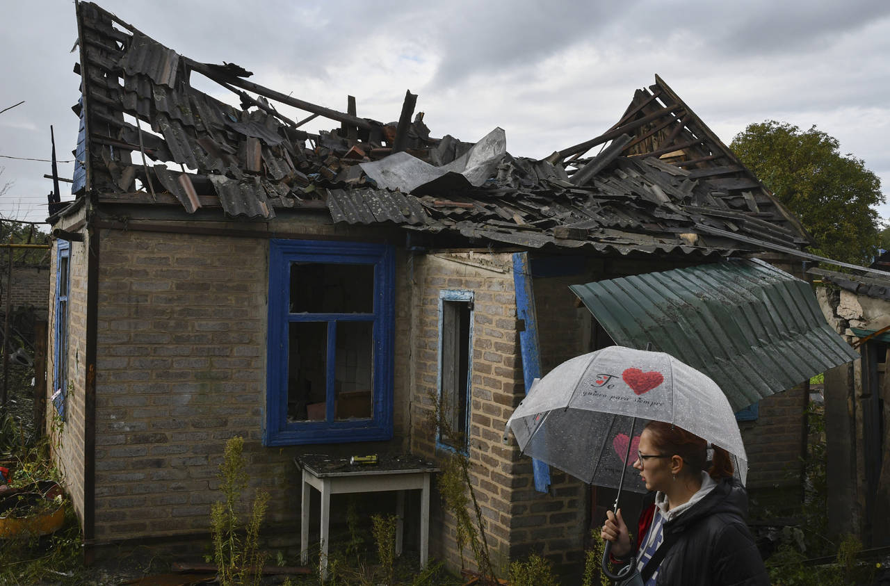 Local resident Ekaterina, 22, stands next to her residential building that was damaged after an ove...