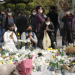 
              People pray for victims of a deadly accident following Saturday night's Halloween festivities on a street near the scene in Seoul, South Korea, Tuesday, Nov. 1, 2022. An Australian survivor of a crowd crush that killed more than 150 partygoers in the South Korean capital of Seoul blamed the huge loss of life on officials’ failure to employ effective crowd controls despite anticipating a massive turnout for the Halloween celebrations. (AP Photo/Ahn Young-joon)
            