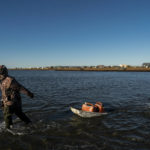 
              Pulling a sled with fuel containers in the lagoon, Joe Eningowuk, 62, left, and his 7-year-old grandson, Isaiah Kakoona, head toward their boat through the shallow water while getting ready for a two-day camping trip in Shishmaref, Alaska, Saturday, Oct. 1, 2022. Rising sea levels, flooding, increased erosion and loss of protective sea ice and land have led residents of this island community to vote twice to relocate. But more than six years after the last vote, Shishmaref remains in the same place because the relocation is too costly. (AP Photo/Jae C. Hong)
            
