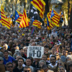 
              Protesters hold ''esteladas'' or Catalonia independence flag as they take part in a demonstration to commemorate the fifth anniversary of an independence referendum that marked the high point of their movement to break away from the rest of Spain, in Barcelona, Spain, Saturday, Oct. 1, 2022. (AP Photo/Joan Mateu Parra)
            