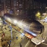 
              The bow of the Soviet submarine K-3 'Leninsky Komsomol' is transported by a platform along the street from the pier to the museum where it will be assembled with the stern and installed as a museum, in the city of Kronstadt, outside St. Petersburg, Russia, Wednesday, Oct. 12, 2022. K-3 'Leninsky Komsomol' (NATO reporting project name "November"), the first nuclear submarine of the Soviet Union was built in 1957 and based in Soviet Navy's Northern Fleet in Murmansk region. In 1967, while transiting the Norwegian Sea, 39 crew members of K-3 died in bow compartments in the fire. (AP Photo/Dmitri Lovetsky)
            