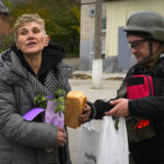 
              A woman gets bread and other aid from a volunteer in Bakhmut, the site of the heaviest battle against the Russian troops in the Donetsk region, Ukraine, Friday, Oct. 28, 2022. (AP Photo/Efrem Lukatsky)
            