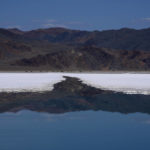 
              Mountains are reflected in a brine evaporation pond at Albemarle Corp.'s Silver Peak lithium facility, Thursday, Oct. 6, 2022, in Silver Peak, Nev. The ponds use evaporation to help separate lithium from brine pumped from underground. The Biden administration on Wednesday, Oct. 19, awarded $2.8 billion in grants to build and expand domestic manufacturing of batteries for electric vehicles in 12 states. A total of 20 companies, including Albemarle Corp., will receive grants for projects to extract and process lithium, graphite and other battery materials, manufacture components and strengthen U.S. supply of critical minerals, officials said. (AP Photo/John Locher)
            