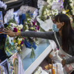 
              A woman touches a photo of the victims of a mass killing attack outside Wat Rat Samakee temple in Uthai Sawan, north eastern Thailand, Sunday, Oct. 9, 2022. A former police officer burst into a day care center in northeastern Thailand on Thursday, killing dozens of preschoolers and teachers before shooting more people as he fled. (AP Photo/Wason Wanichakorn)
            