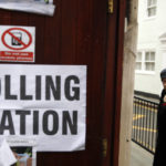 
              FILE - A woman arrives at a polling station in London, Thursday, Dec. 12, 2019.  Under Britain's parliamentary system, the public never actually votes for its prime minister. Instead, voters tick the box for a representative from their local area, who then becomes one of Britain’s 650 Members of Parliament. The party that wins a majority forms a government and puts their leader into the prime minister's seat. (AP Photo/Thanassis Stavrakis, File)
            